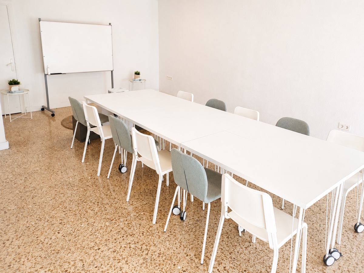 Aula configurada como sala de juntas en Almeria, mesa larga y pizarra